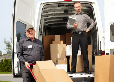 Moving team with van safety equipment and packed furniture